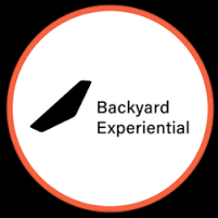 Logo with a black stylised shape to the left and the words "Backyard Experiential" to the right, inside a white circle bordered with red.