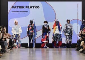 Five models strut down the runway showcasing diverse outfits by Patrik Platko from Coventry University, captivating the audience on both sides at Graduate Fashion Week 2024 (GFW).