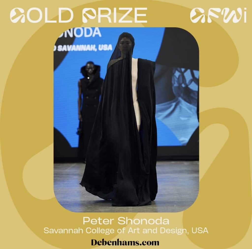 Model walking on a runway wearing a black, full-body covering outfit with a masked face. The background displays text about a gold prize winner from Savannah College of Art and Design, USA.